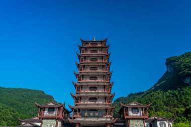 Zhangjiajie, Çin - Ağustos 2019: Geleneksel Çin tarzı ahşap kule pagoda Hunan Eyaleti 'ndeki Zhangjiajie ulusal parkının Wulingyuan girişinde duruyor.