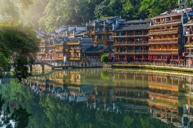 Feng Huang, Çin - Ağustos 2019: Fenghuang Eski Kasabası 'nın merkezinden akan Tuo Nehri' nin kıyısındaki eski tahta Diaojiao evlerinin antika sepia manzarası