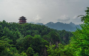 Tianzi dağ sırasının baş döndürücü kaya sütunlarına bakan bir dağın tepesinde geleneksel Çin mimari tapınağı binası Avatar dağları doğa parkı, Zhangjiajie, Çin