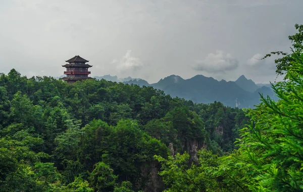 Traditional chinese architecture pagoda temple building on top of a mountain peak overlooking the stunning rock  pillars of the Tianzi mountain range, Avatar mountains nature park, Zhangjiajie, China