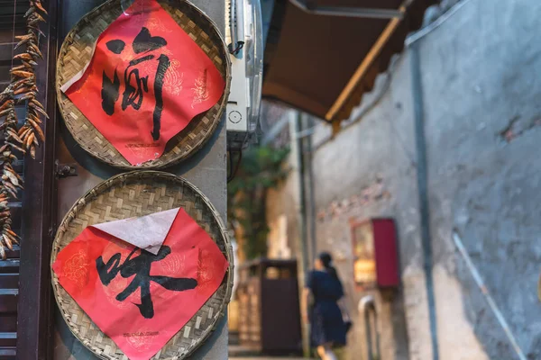 重慶市 8月2019 赤の背景に黒インクで書かれた中国の文字は ラウンドウィッカートレイ慈チーコウ古代の町の路地にある小さな地元の店の壁に添付内 — ストック写真