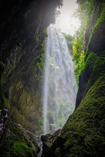 中国武隆 2019年8月 一群游客在重庆武隆国家公园龙水峡峡谷巨瀑布下狭窄的小径上行走 — 图库照片