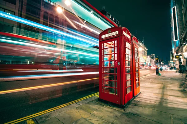 Sentiers lumineux d'un bus à deux étages à côté de l'emblématique cabine téléphonique de Londres — Photo