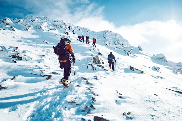 Um grupo de alpinistas ascendendo uma montanha no inverno — Fotografia de Stock