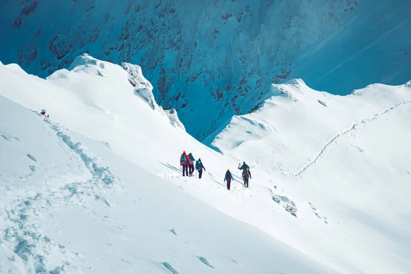 Um grupo de alpinistas ascendendo uma montanha no inverno — Fotografia de Stock