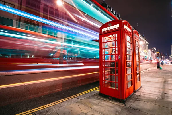 Könnyű pályák a mellett a legendás telefonfülke a londoni emeletes busz — Stock Fotó