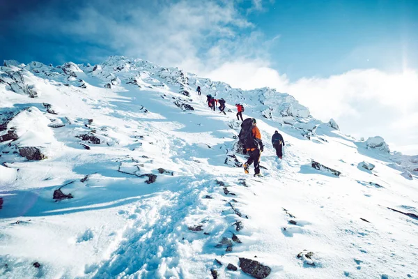 Un groupe d'alpinistes montant une montagne en hiver — Photo