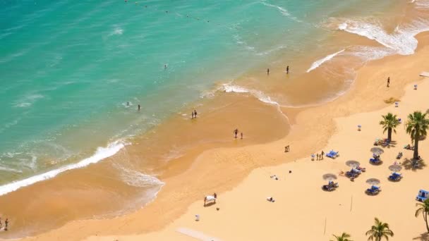 Gente bañándose al sol, nadando y jugando en la playa de España — Vídeo de stock