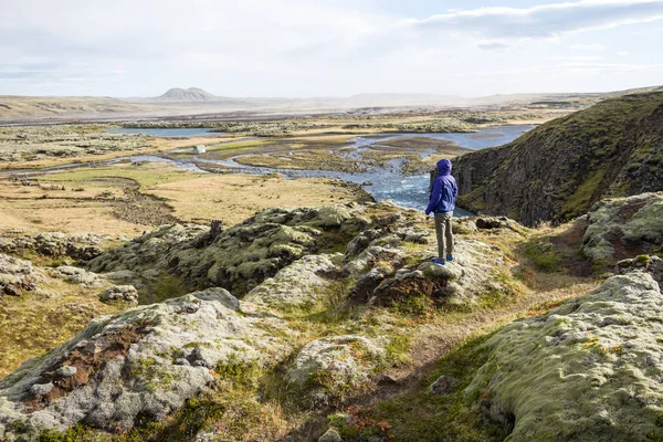 Junge Frau blickt auf majestätische isländische Landschaft — Stockfoto