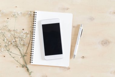 Defter ve ahşap masa üstü görüş Smartphone'da düz yatıyordu fotoğrafı