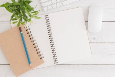 Beyaz ahşap masa üstten görünüm, düz üstünde boş açık defter fare ve klavye ile ofis büro fotoğraf koymak