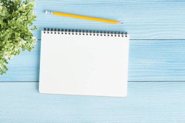 İle defter ve kalem mavi zemin üzerine boş, düz Fotoğraf defter mesajınız için yatıyordu