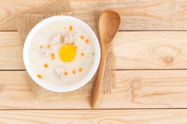 Domuz lapası bir fincan kahverengi ahşap zemin üzerinde yumurta koymak.