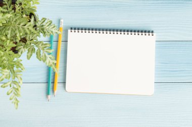 İle boş defter ve kalem mavi zemin üzerine