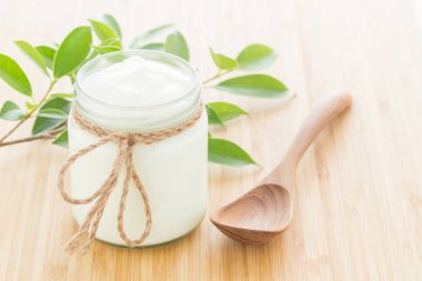 Yoğurt Beyaz ahşap masa sağlıklı gıda kavramı üzerinde cam şişelerde