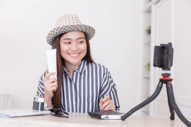 Genç Asyalı kadın seyahat blogger güneş kremi holding