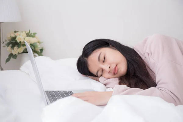 Asian women are sleeping because they are tired of work from laptop computer at bedroom — Stock Photo, Image