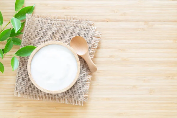 Jogurt v dřevěné misce na konceptu zdravé potraviny bílý dřevěný stůl — Stock fotografie