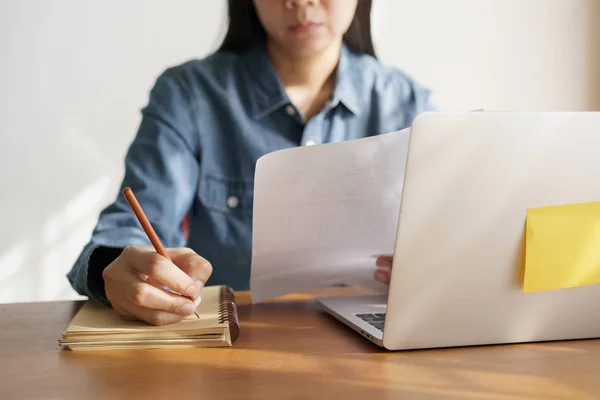 Asian women take notes with a pencil in the office, business woman working