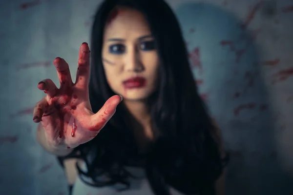 Die Hände der asiatischen Frau sind blutig rot vor dunklem Hintergrund — Stockfoto