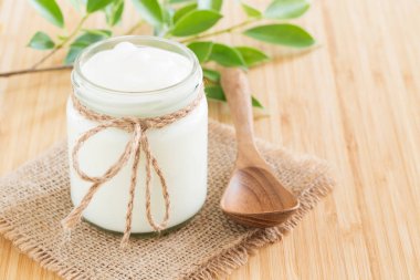 Yoğurt bambu ahşap masa, sağlıklı gıda kavramı üzerinde cam şişelerde