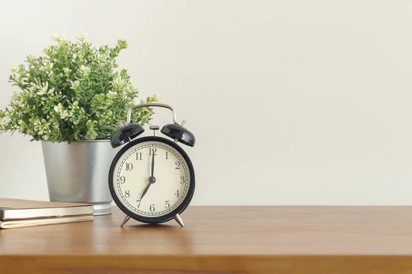 Reloj despertador negro sobre escritorio de madera sobre fondo blanco — Foto de Stock