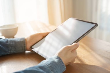 Ahşap masa ofis sabahı tablet üzerinde çalışan bir kadın