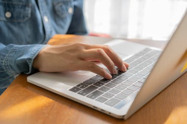 Asyalı kadın ahşap masa, kadınlar birlikte çalıştığınız iş üzerinde bir dizüstü bilgisayar kullanarak Office kitap notları