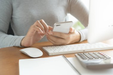 Asyalı kadınların eli ofiste akıllı telefon ve bilgisayar kullanıyor