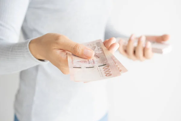 Mujer asiática contando dinero sobre fondo blanco. Dinero baht de Tailandia en su mano . — Foto de Stock