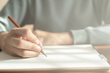 Asyalı kadınlar el ahşap masanın üzerine notlar alıyor.