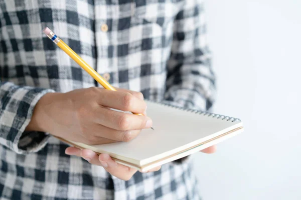 Hautnah auf handgeschriebenem Papier Notizbuch. auf junge Frau mit Notizbuch in der linken Hand und Tagebuch schreibender rechter Hand. — Stockfoto