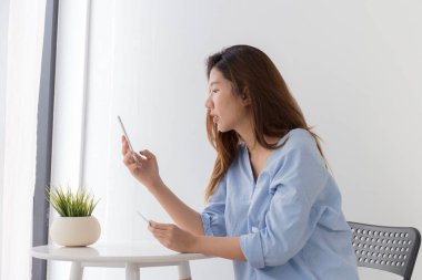 Asyalı kadınlar akıllı telefonlar ve kredi kartı ile ödeme