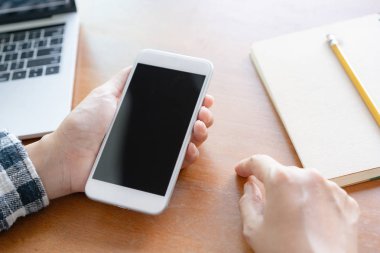Ofiste masa arka planında akıllı telefonu kullanarak eli kapatma.  