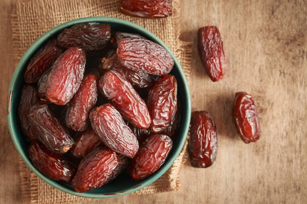 , ahşap masa arka plan üzerinde fincan palmiye meyve tarihler resmi yakın