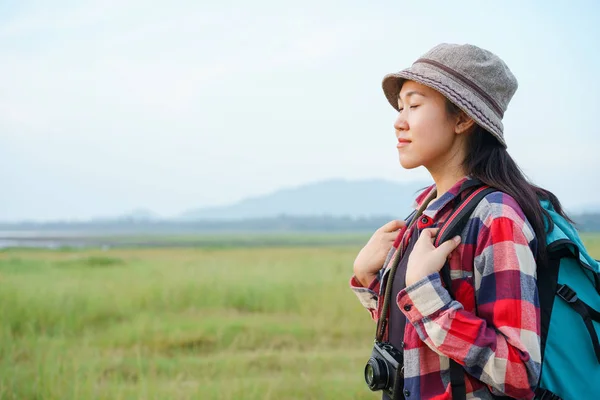 Asian women are closing their eyes and enjoying nature on the  mountains and sky background.