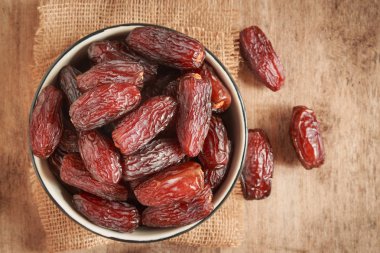 tarihi, ahşap masa arka plan üzerinde fincan palmiye meyve tarihleri resmi yakın. Tarihler palmiye meyvesi kuru snack sağlıklı.