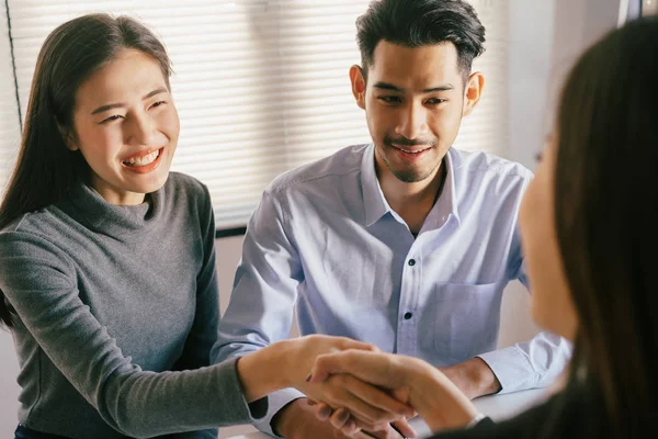 Närbild av säljare skakar hand med älskare som är kunder på hennes kontor i huset köpeavtal asiatiska kvinnor och män leende glatt — Stockfoto