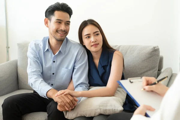 Азиатская пара объединяется, чтобы поддержать, сидя на диване в комнате психиатра, чтобы проконсультироваться с психическими проблемами врача, здоровья и болезней концепции — стоковое фото