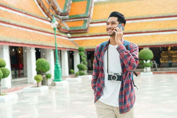 Asiatico uomo turista walking talk smart phone e sorriso a Wat Suthat Thepwararam Ratchaworawihan Bangkok — Foto Stock