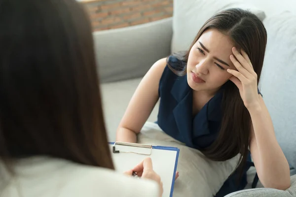 Asiatiska kvinnor har huvudvärk är sjuka. Så hon gick för att se en läkare för att kontrollera symptomen — Stockfoto