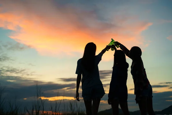 group teen women asian drinking beer from bottles in the midst of nature