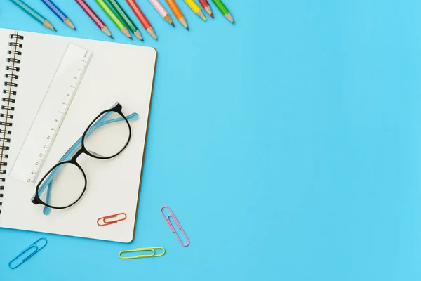 Flachbild-Foto vom Schreibtisch mit Buntstift, Büroklammer, Lineal, Notizbuch, Brille, Draufsicht auf den Kopierraum — Stockfoto