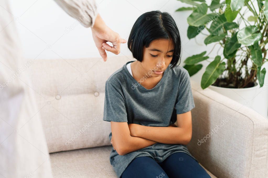 Asian mother is angry and scold her daughter while sitting on the sofa because of bad behavior