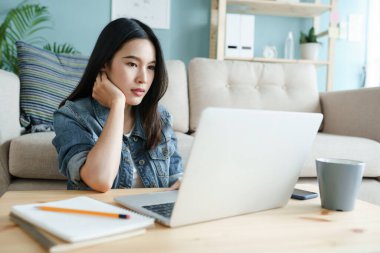 Evden çalışıyorum. Genç bir kadının bilgisayar kullanması güzel bir şey. Sabahleyin evdeki oturma odasında yerde otururken.