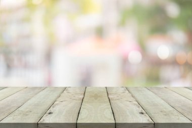 Alışveriş merkezinde boş ahşap masa ve yeşil bulanık arka plan.