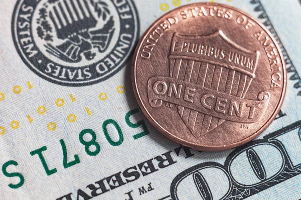 Makro fotoğraf 100 ABD Doları arka planda ve bir kuruş. Amerikan para 2016 nominal değeri 1 cent çok yakın fotoğrafı ters.