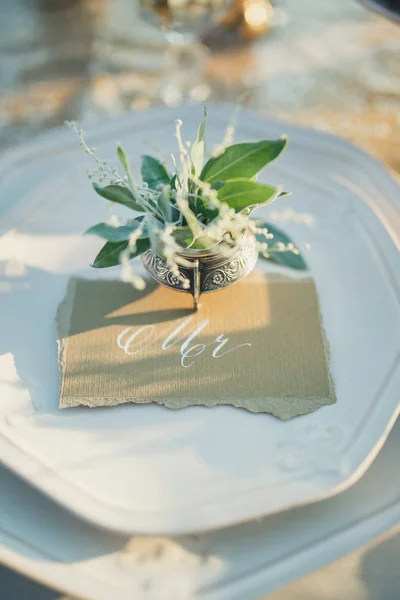 Düğün kartı tasarımı. Kartpostal tasarımı. Altın arka plan. Kaligrafik tasarım elementleri. Üzerinde yazı olan düğün kartı ve beyaz tabakta çiçekler olan metal mürekkep hokkası..