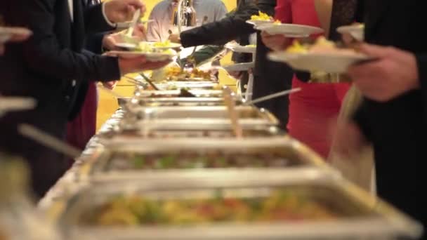 Gruppo di persone ristorazione buffet cibo al coperto in ristorante di lusso con carne — Video Stock