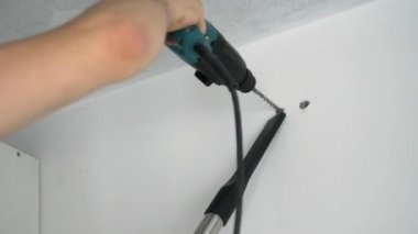 Bir Builder duvara bir delik matkaplar
